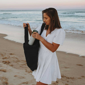 Model on beach using black tote bag canvas