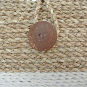 Detail view ofwooden button on the front of white basket beach bag