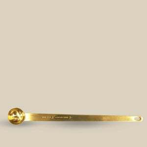 Gold teaspoon on beige background
