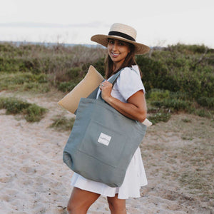 Woman on beach styled with blue tote bag plain