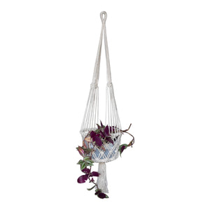 Full view of the single white macrame potholder styled with a purple plant 